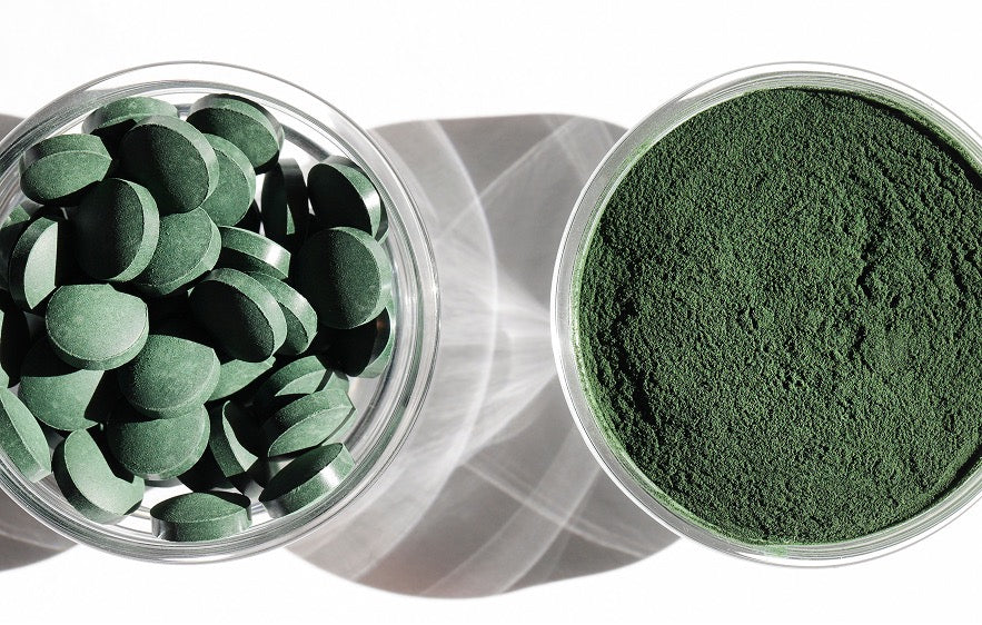 Image de deux contenants, l'un avec de la spiruline en comprimés et l'autre avec de la spiruline en poudre. 