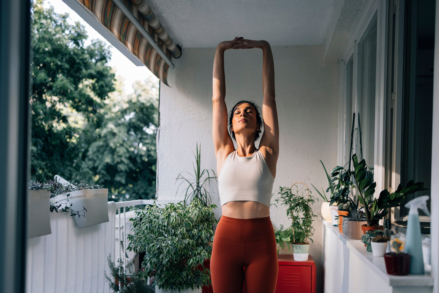 Femme pratiquant des étirements sur une terrasse dans un cadre sportif et bien-être