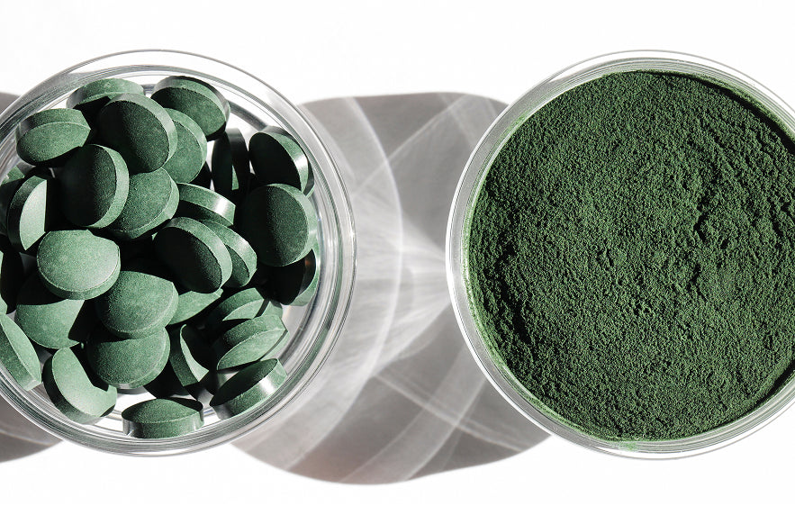 Image de deux contenants, l'un avec de la spiruline en comprimés et l'autre avec de la spiruline en poudre. 